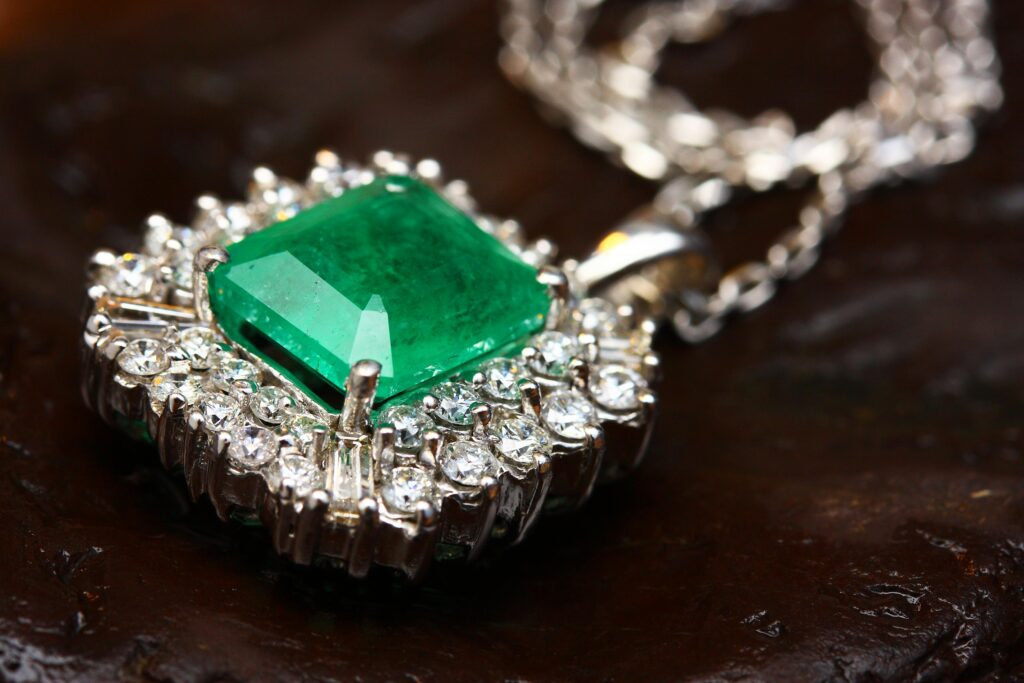 Stunning emerald pendant necklace in white gold with shimmering diamonds, epitomizing luxury and elegance.